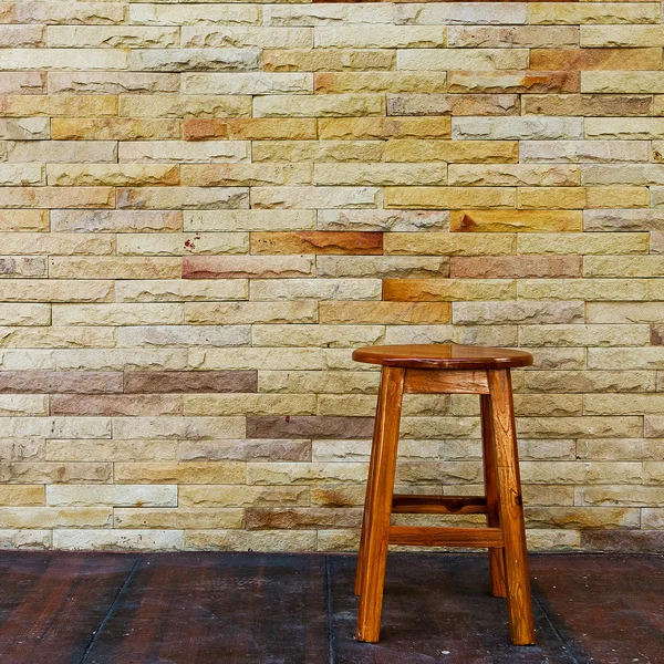 Vintage wooden chair with stone wall background — Stock Photo, Image
