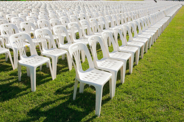 Rows of empty white chairs waiting for the audience