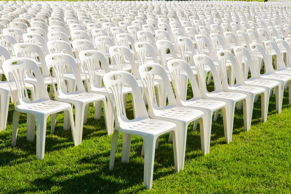 Rows of empty white chairs waiting for the audience