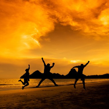 İnsanlar gün batımında sahilde