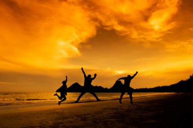 İnsanlar gün batımında sahilde