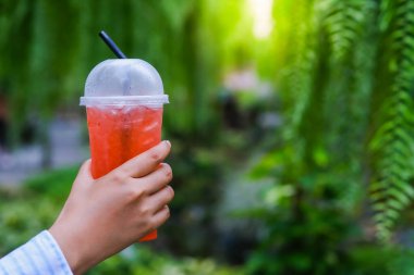 Kızın eli fincanı gül çayıyla tutarak bahçede içmeye hazırdı..