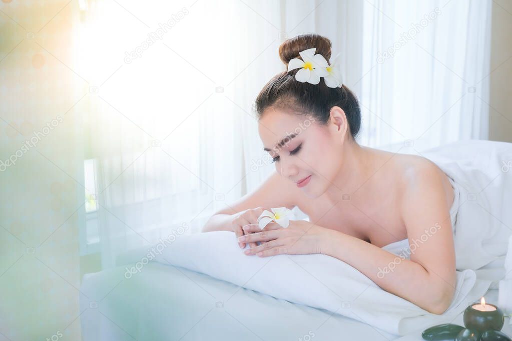 Asian woman relaxing while waiting for a spa massage.