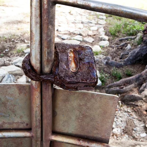 Старый винтажный замок, закрепленный на металлическом заборе — стоковое фото