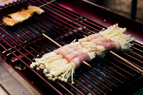 Paddestoel omwikkeld met ham, varkensvlees, boter, gegrilde spiesjes. — Stockfoto