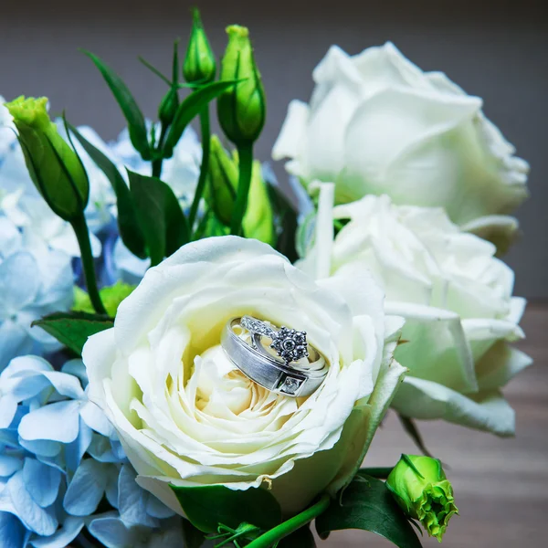 Huwelijksringen met roze bloemen — Stockfoto