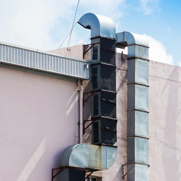 Bir endüstriyel metal egzoz havalandırma çıkışı bir duvarına bitişik — Stok fotoğraf