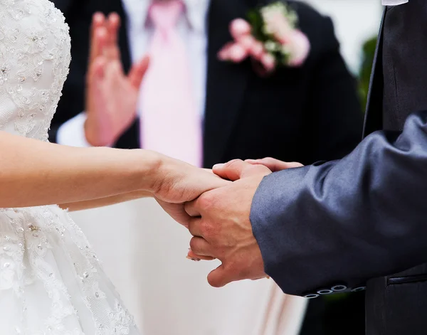 Bride and groom holding hands in wedding celemony — Stock Photo, Image