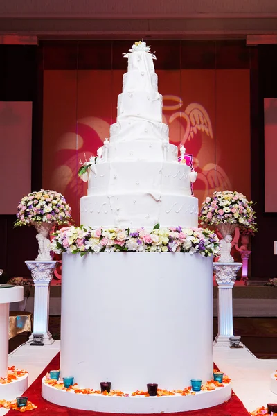 Багаторівневий білий весільний торт на срібній основі та рожевий плащ — стокове фото