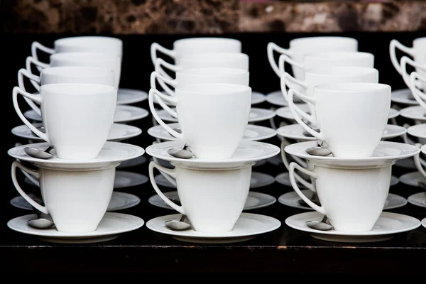Многие белые чашки кофе в очереди за шведским столом — стоковое фото