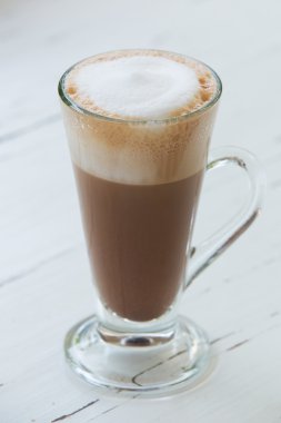 desen ahşap arka plan üzerinde beyaz bir fincan kahveyle