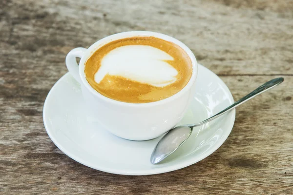 Coffee with pattern in a white cup on wooden background — Stock Photo, Image