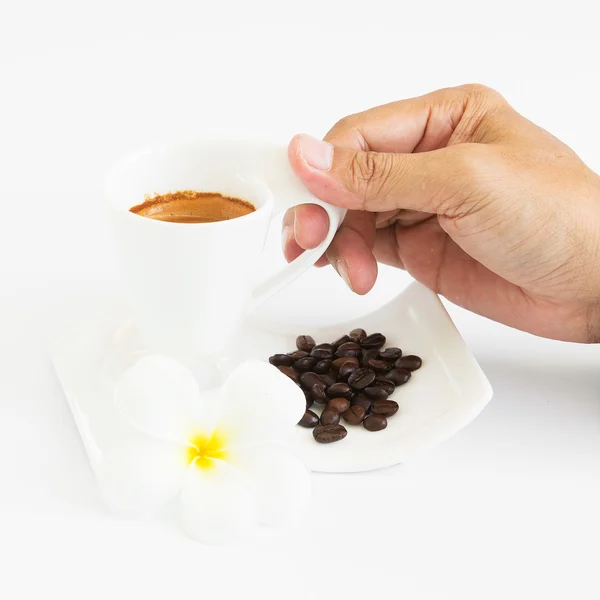 Espresso-Kaffeetasse mit Kaffeebohnen und Blumen auf weißem Bac — Stockfoto