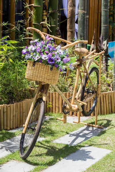 Lila blommor på en bambu cykel korg. — Stockfoto