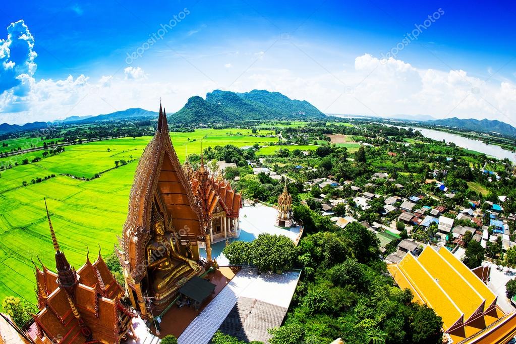 Golden buddha statue with mountain, Wat Tham Sua(Tiger Cave Temp