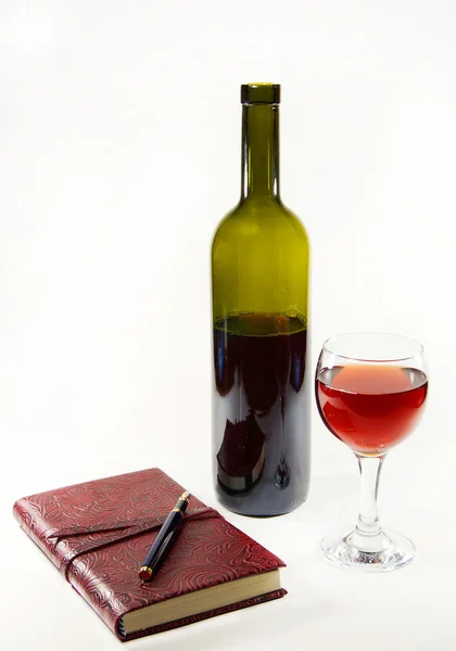 Copa con vino tinto, botella y diario — Foto de Stock