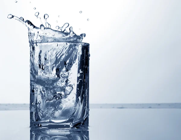 Water spray and ice in a glass — Stock Photo, Image