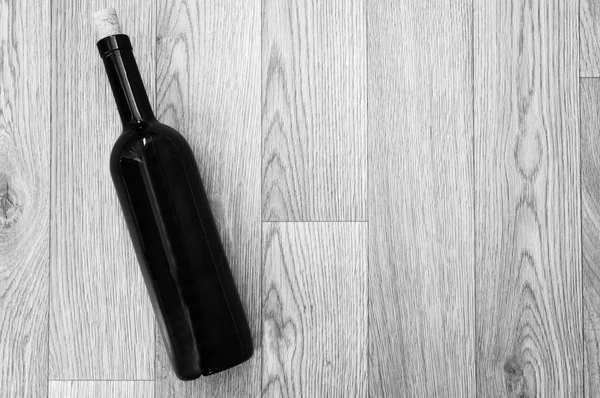 Bottle of wine on black-and-white wooden table — Stock Photo, Image