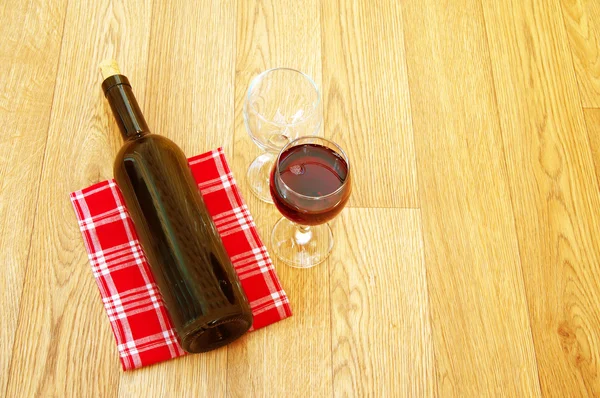 Bottle on a napkin and glasses of wine — Stock Photo, Image