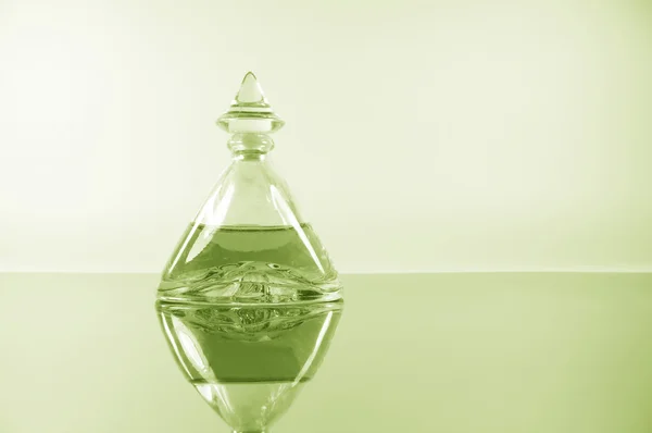 Pale lime perfume on mirror surface — Stock Photo, Image