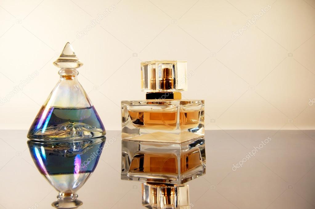two bottles perfume on mirror surface