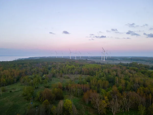 Wind turbines on sunset at summer evening. Renewable energy