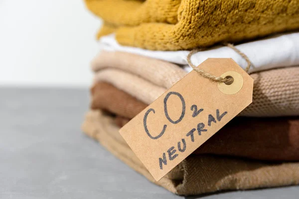 Clothes in stack with carbon emission paper recycled label