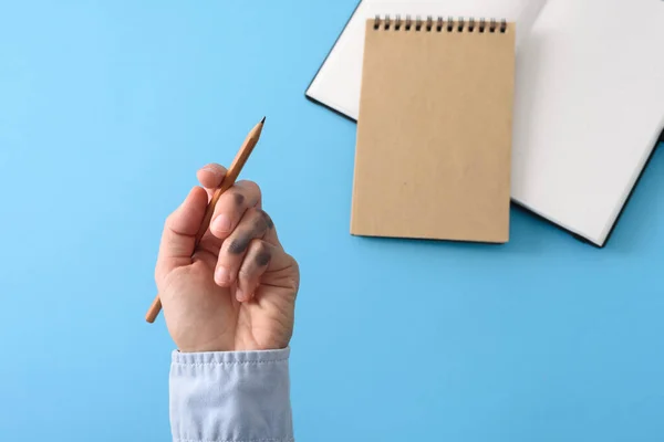 Dirty left hand in blue shirt after writing. Left hander day concept.