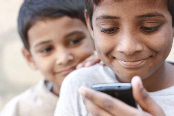 Enfants jouant sur un téléphone mobile — Photo