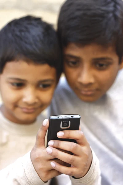 Barn som leker på mobiltelefon Royaltyfria Stockfoton