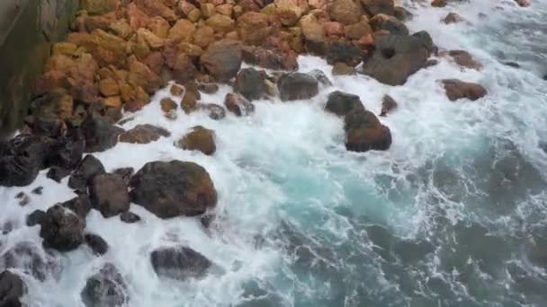 Modré vlny černého moře, bušící do hnědých skal. Horní pohled na mořskou pěnu. Stone — Stock video