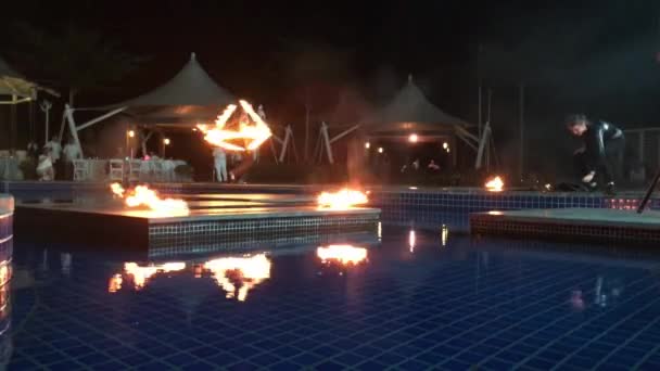 Люди крутят цепи огня ночью у фонтана в шоу отеля — стоковое видео