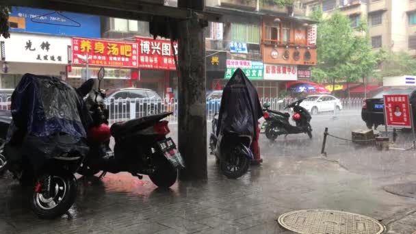 Guyang, China - 07.20.2017: chuva forte em um dia ensolarado na rua da China — Vídeo de Stock