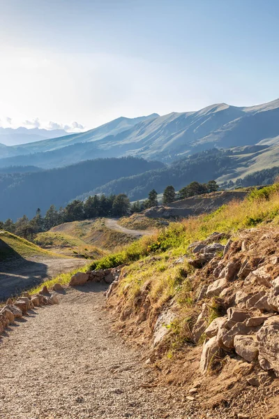 winding mountain trail goes near the colorful mountains. sunny day in a mountain valley. North Caucasus, Russia