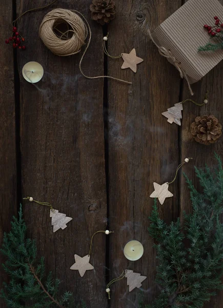 モミの枝、キャンドル、ギフトボックス、木製のクリスマスのおもちゃとクリスマスと新年の組成物。素朴な木の背景、コピースペース. — ストック写真