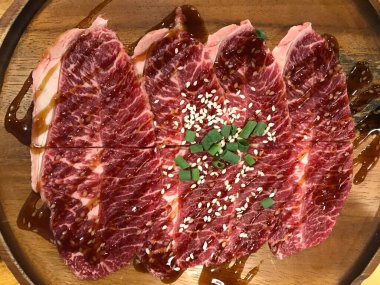 Tabaktaki çiğ et dilimi servise hazır. Sığır eti üst görünümü kapalı.