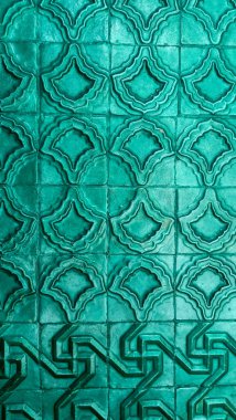 Parlak yeşil-mavi tekrarlayan geometrik desenli dikey arkaplan dokusu.