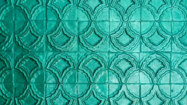 Parlak yeşil-mavi tekrarlayan geometrik desenli yatay arkaplan dokusu.