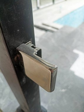 Mimari detay: Görünür vida ve bağlantıları olan siyah metal bir tırabzanın merdiven tabanına yerleştirilmesi.