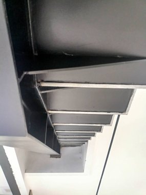 Lüks bir iç odanın köşesinde sürgülü cam kapılar, dairesel bir sütun ve ahşap bir tavan var..