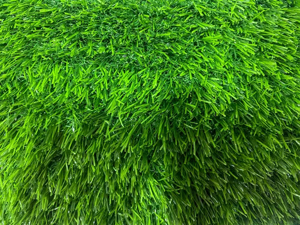 Sık, eşit kesimli, parlak yeşil sentetik çimen dokusu, genellikle dekorasyon için kullanılır..