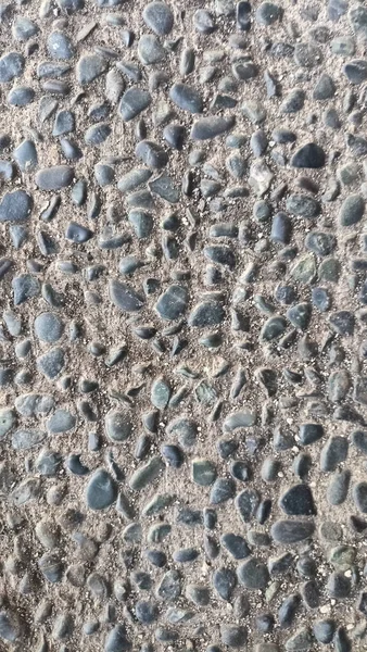 Yoğun gri ve kahverengi çakıl yüzey dokusu, tipik yürüyüş yolları ya da dış zemin döşemeleri için.