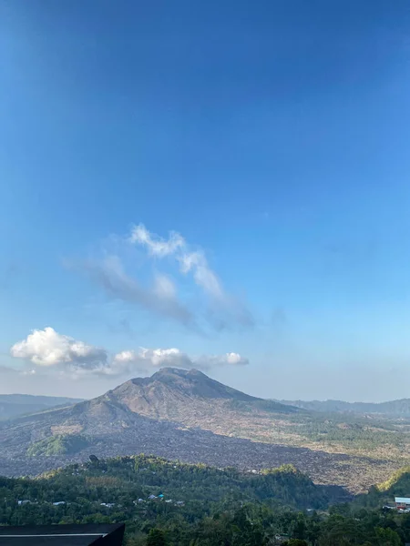Açık mavi gökyüzü ile geniş bir dağ manzarası, yüksek irtifada huzurlu bir atmosfer..