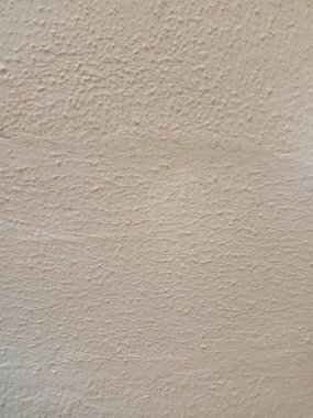 Sert, soluk renkli duvar dokusu, eski alçı ya da beton gibi görünüyor..