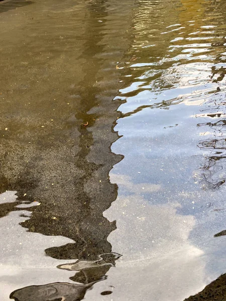Su yüzeyi, bir alışveriş merkezinin çeşme alanının çevresini ince dalgalanmalarla yansıtıyor..