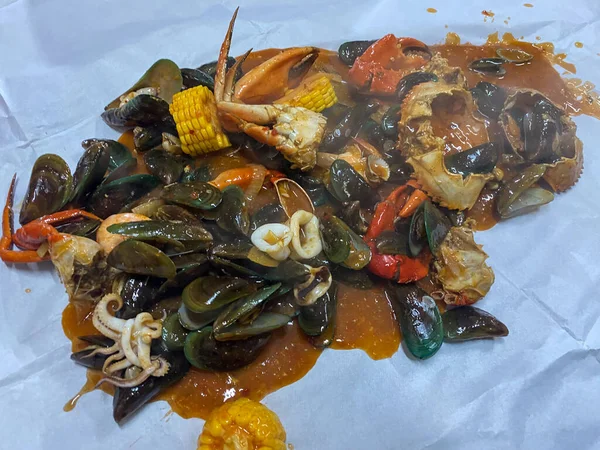 Beyaz tabakta yeşil midye, mürekkep balığı ve sebzeli baharatlı deniz ürünleri..