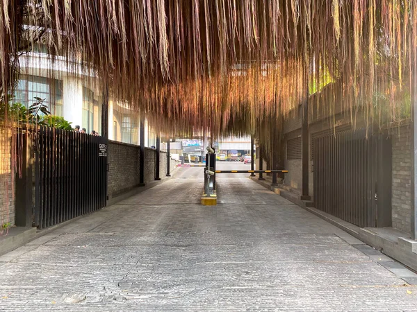 Eğri ahşap panelleri olan alçak çatılı giriş, göz alıcı modern mimari tasarım..