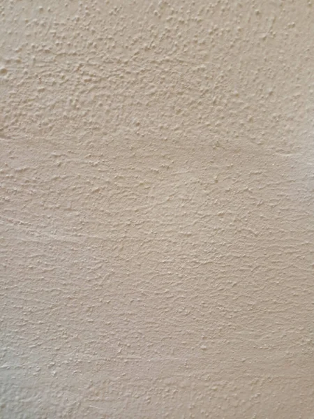 Sert, soluk renkli duvar dokusu, eski alçı ya da beton gibi görünüyor..