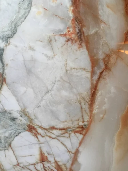 Yakın plan zengin damarlı mermer levha, krema, kahverengi ve pembe / kırmızı karıncalanma karışımı.