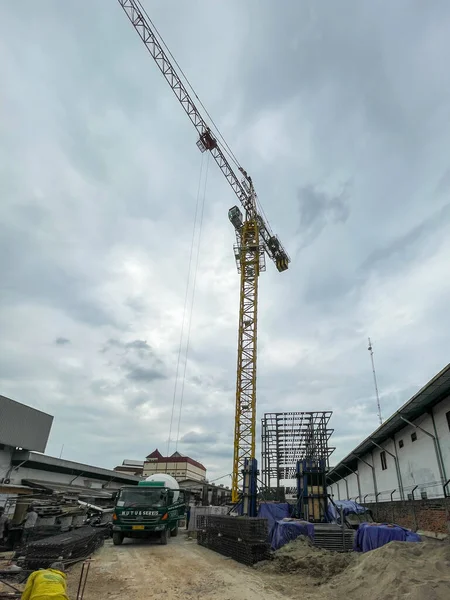 Jakarta, Indonesia - 27 November 2025: Tower crane in the foreground of a large construction project.